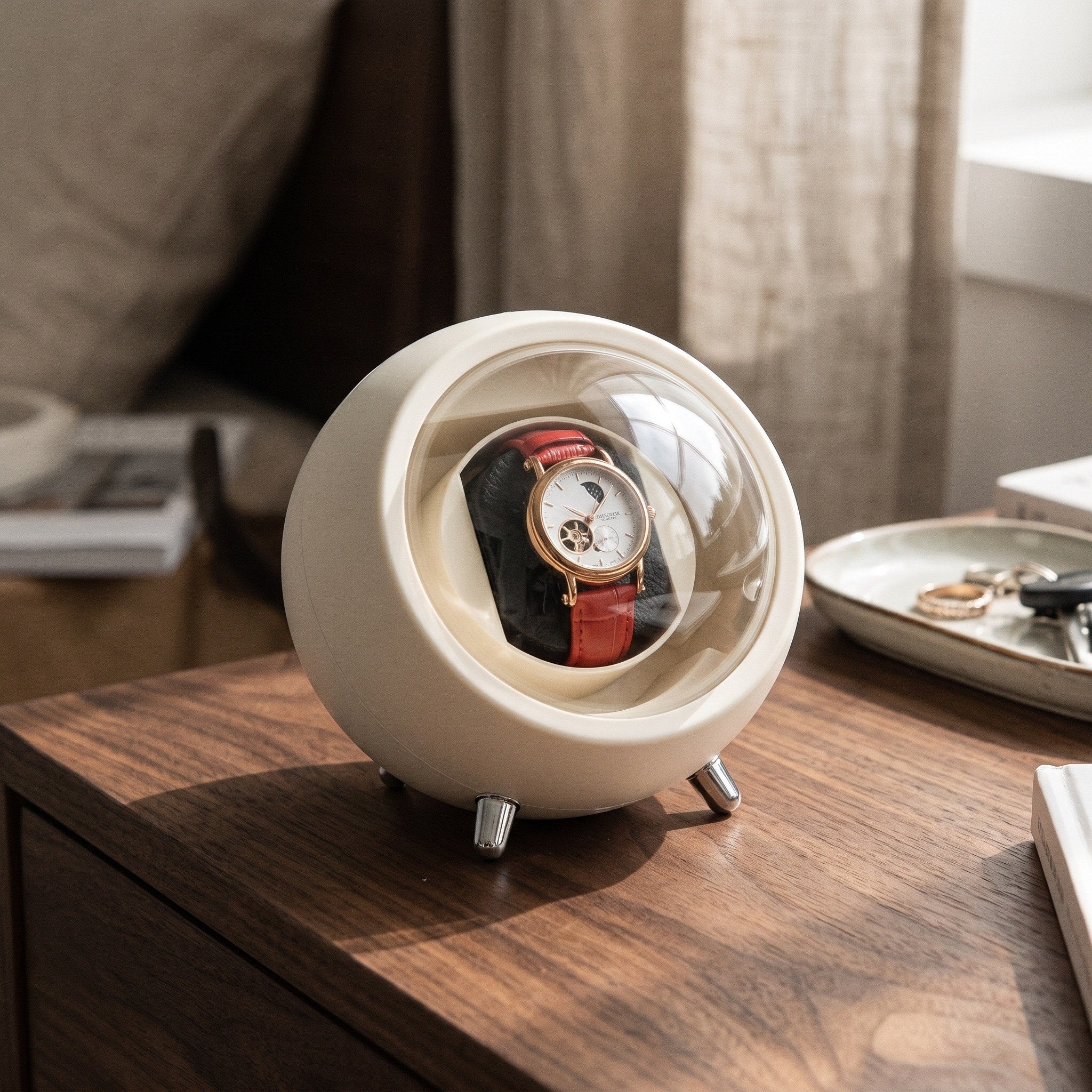 Cream watch winder on a walnut dresser