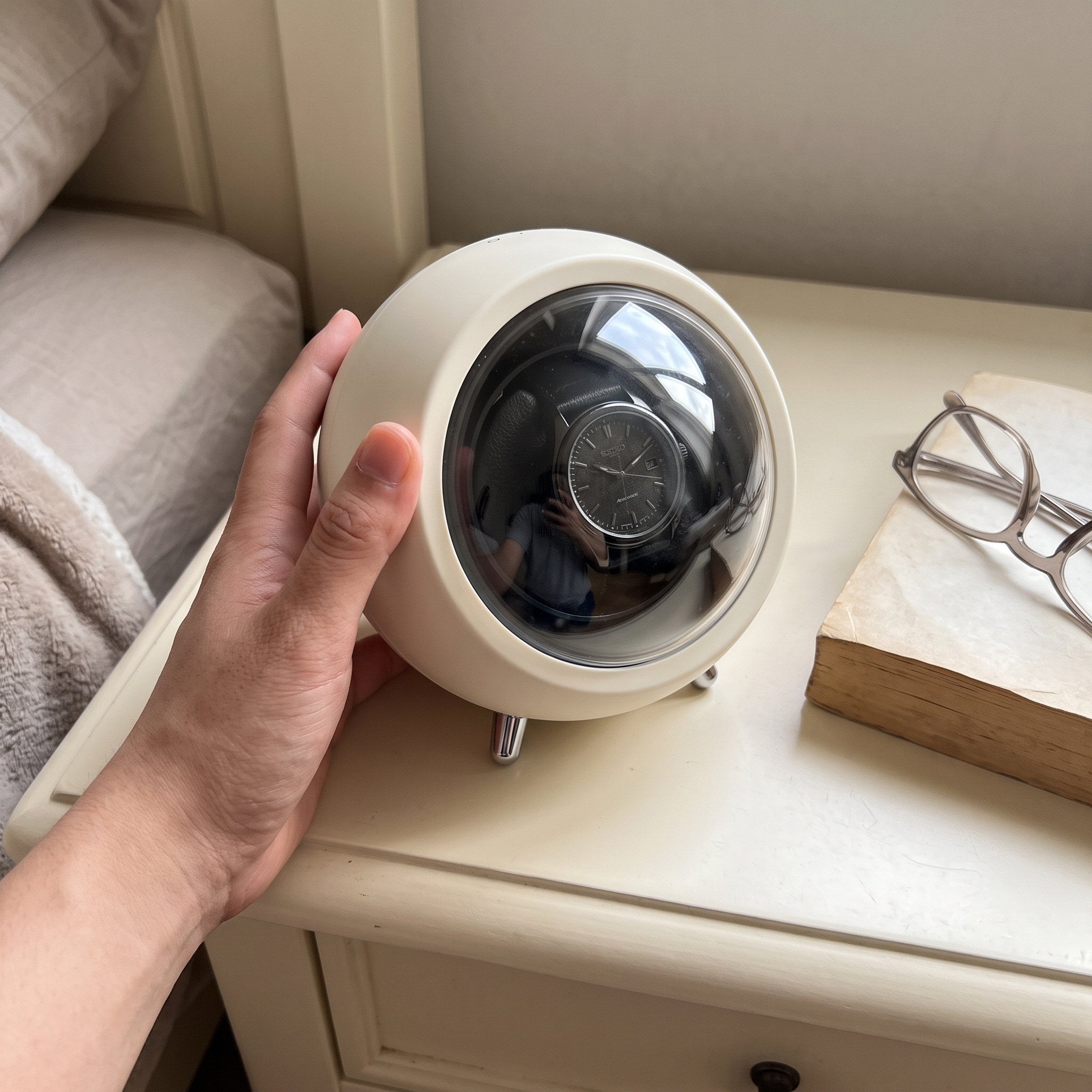 Hand steadying an Cream winder on a bedside table