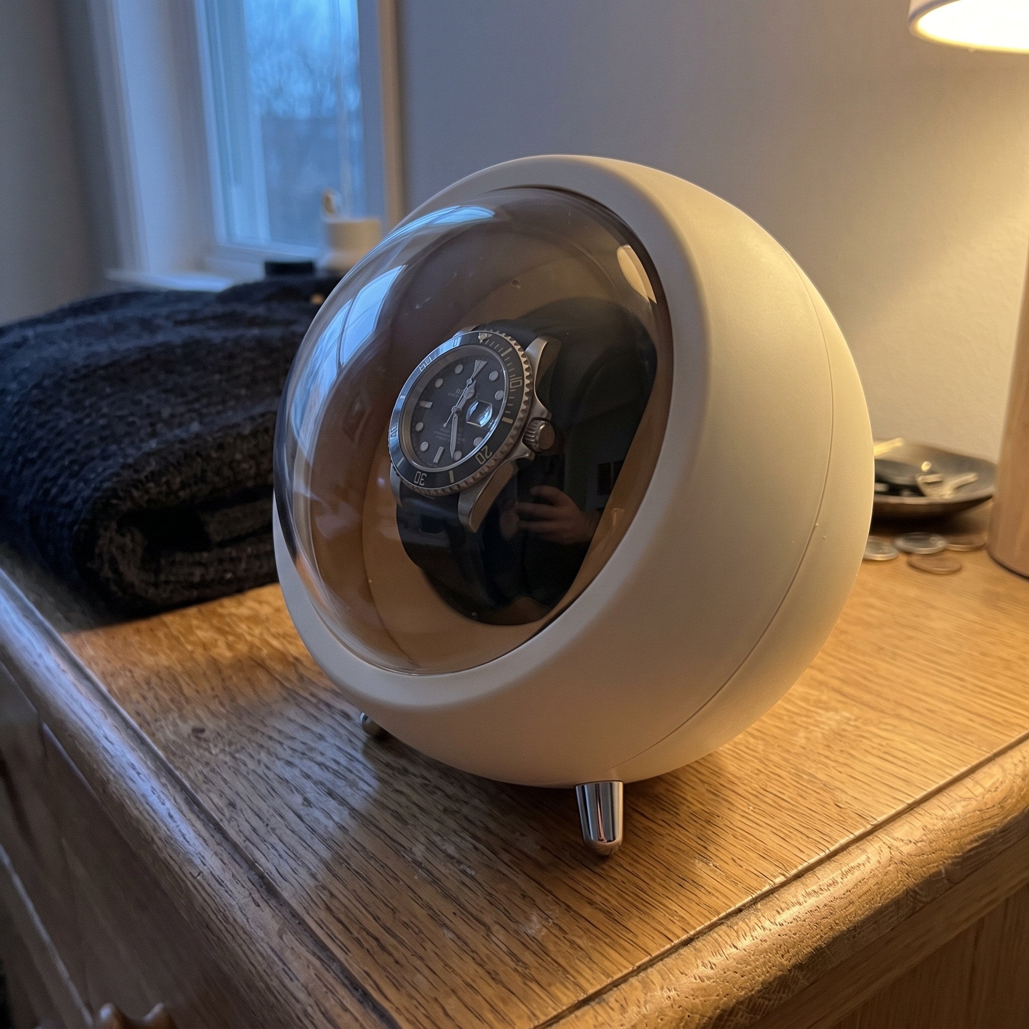 Cream winder beside a folded sweater at blue hour